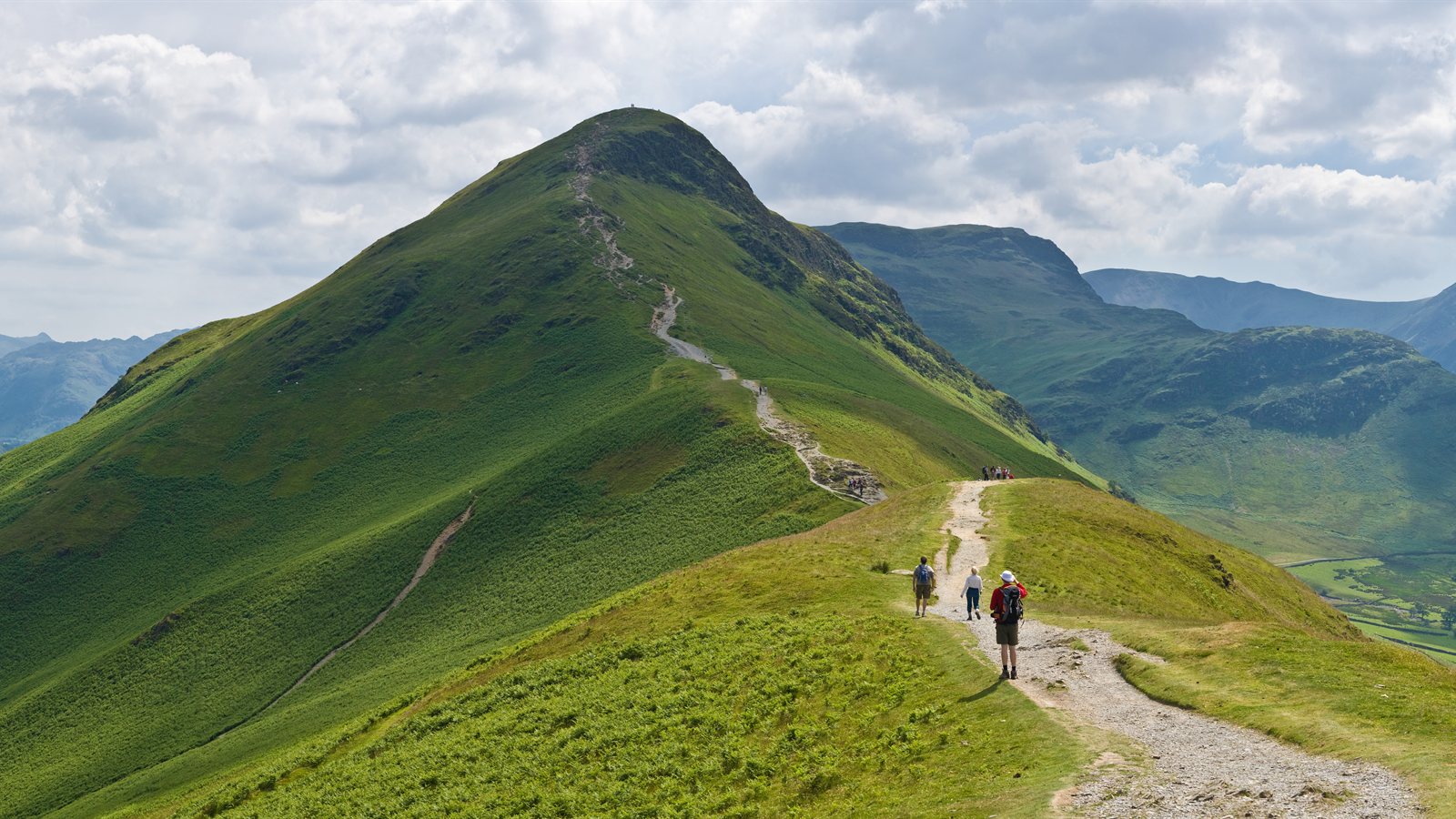 Walkers on a ridge path above a lake